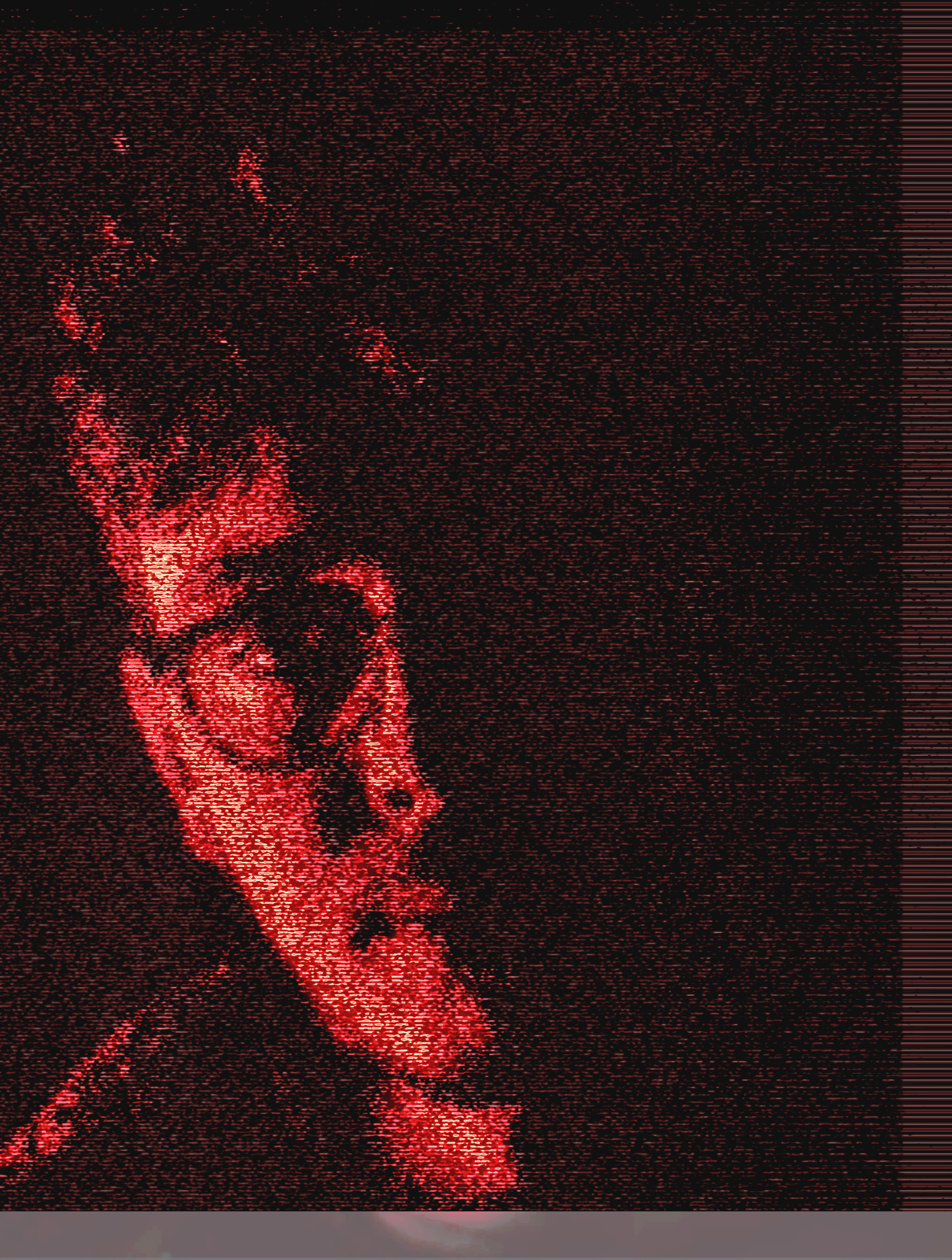 Close-up of a person's face with glasses illuminated by red digital glitch effects on a dark background.