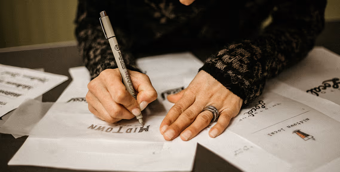 Person sketching logos