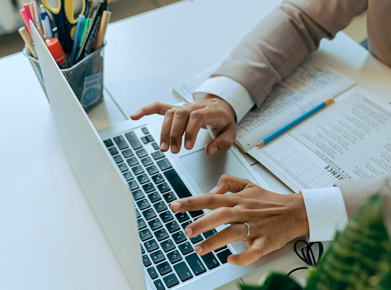 Person in brown blazer using laptop