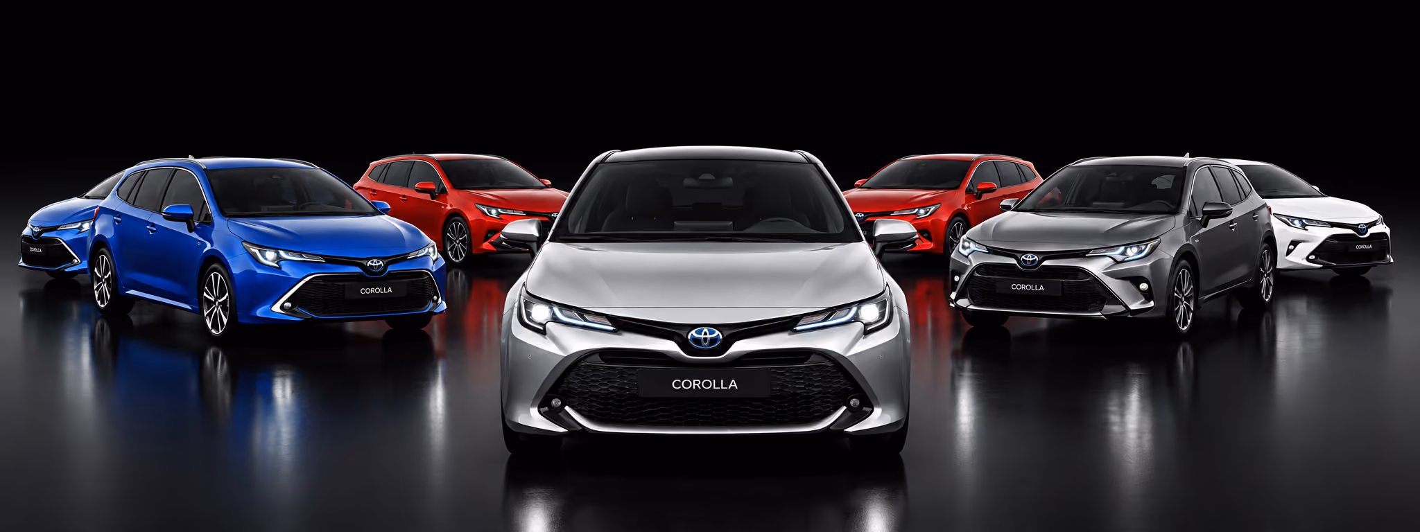 Seven Toyota Corolla cars in various colors arranged in a semi-circle on a reflective black surface.