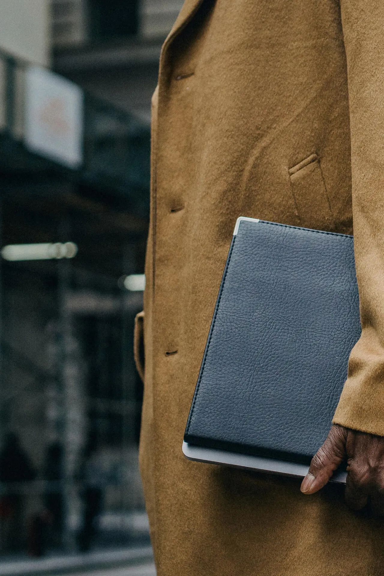 man with folder in overcoat