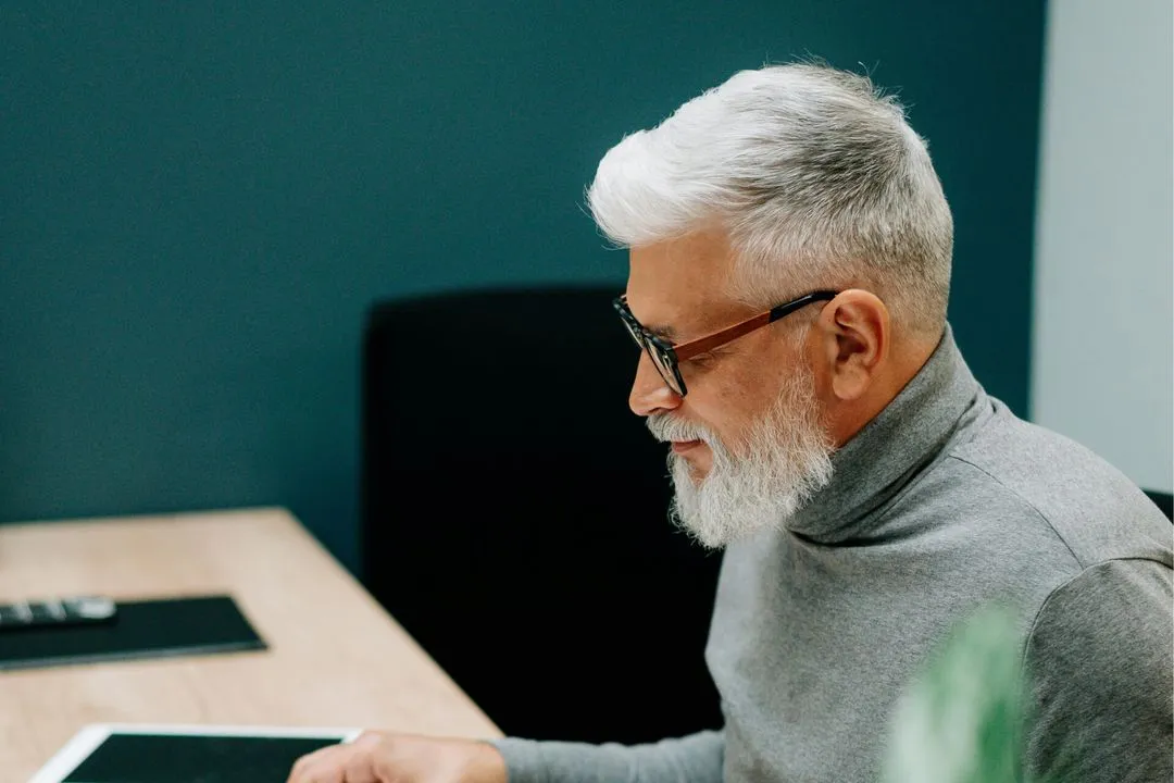 elderly man reading documents in the office