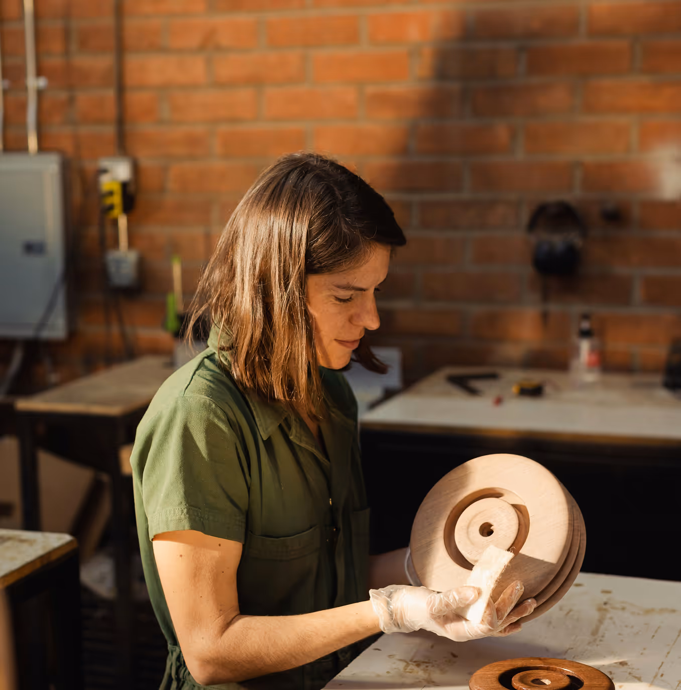 woman sitting working with wood