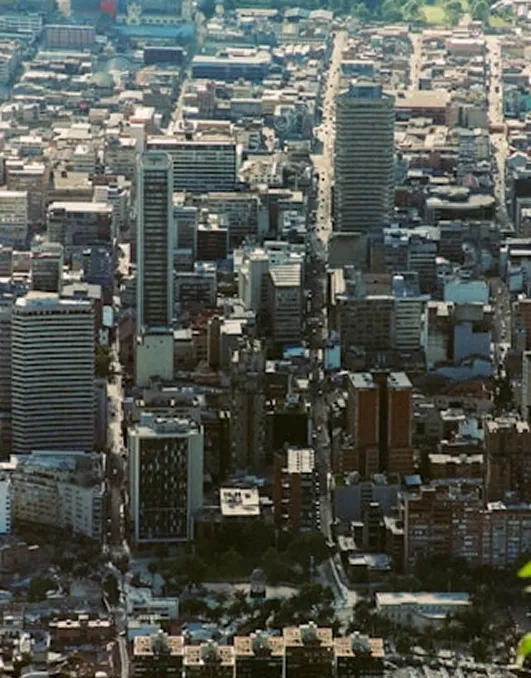 Aerial view of a densely built urban cityscape with numerous high-rise buildings and busy streets.