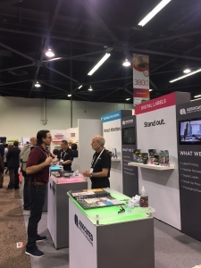 Two men converse at a trade show booth