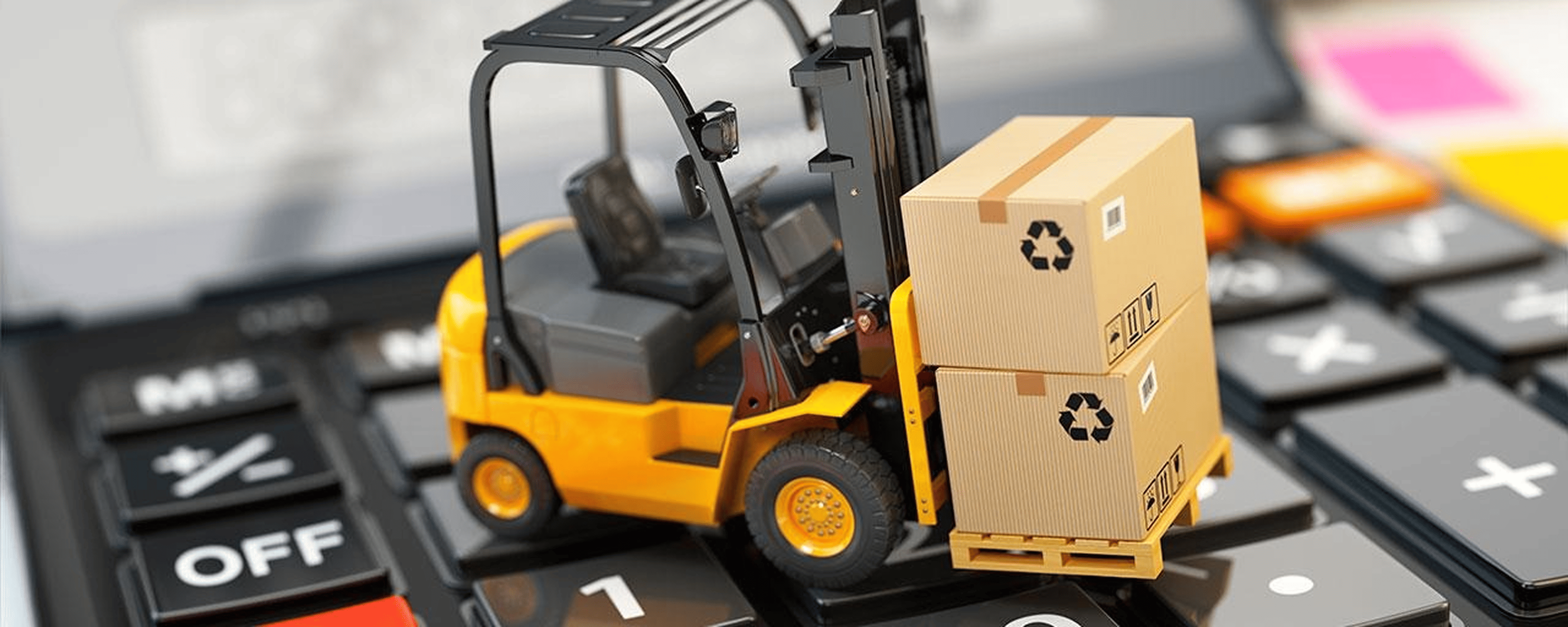 Miniature yellow forklift carrying two stacked cardboard boxes on a large calculator keypad