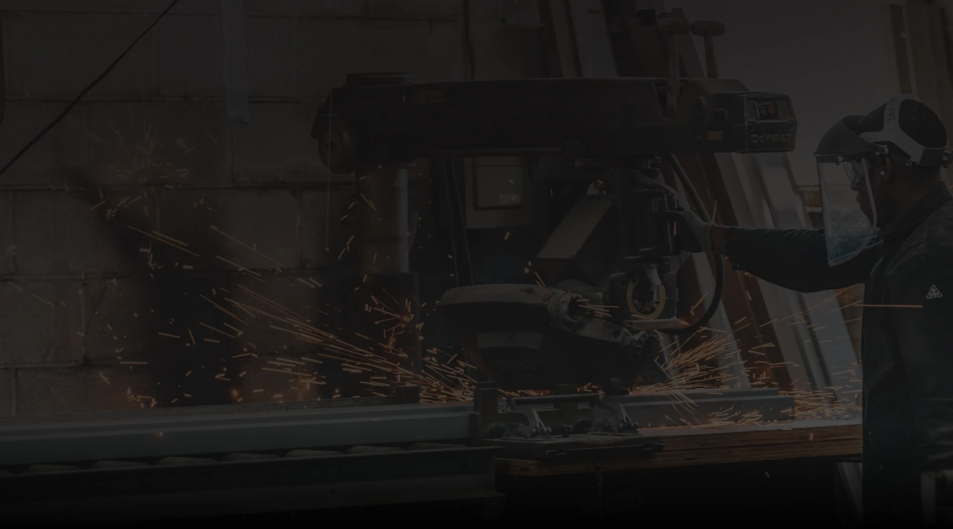 Worker using metal-cutting saw, sparks fly