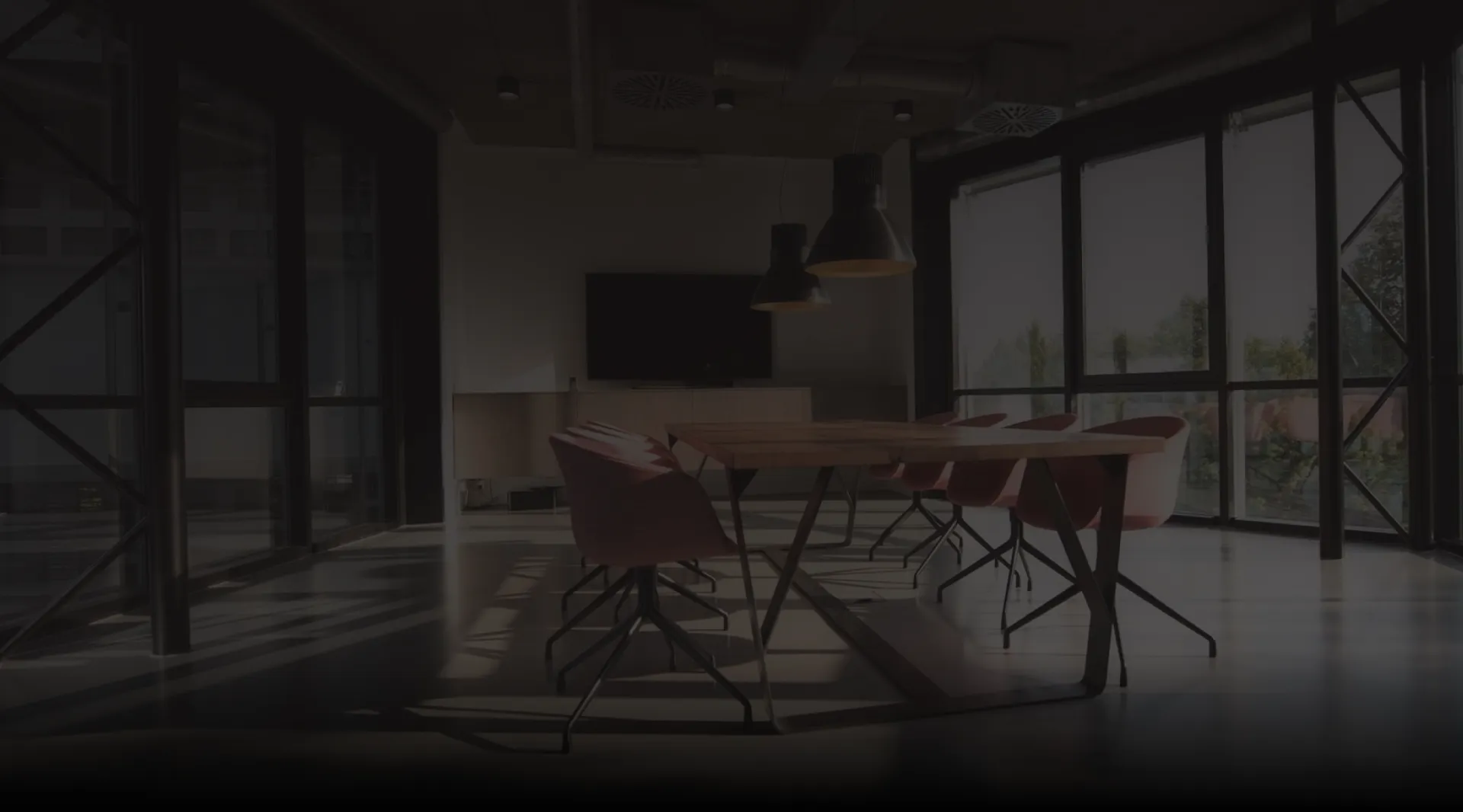 Long wooden conference table with red chairs