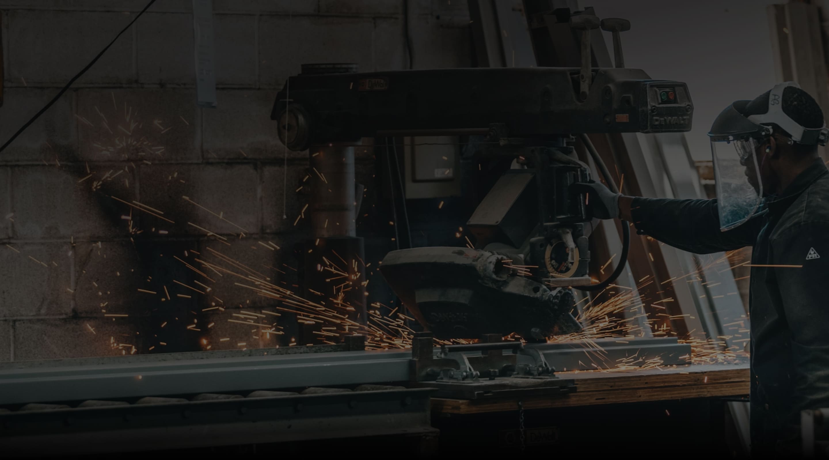 Worker cutting metal as sparks fly