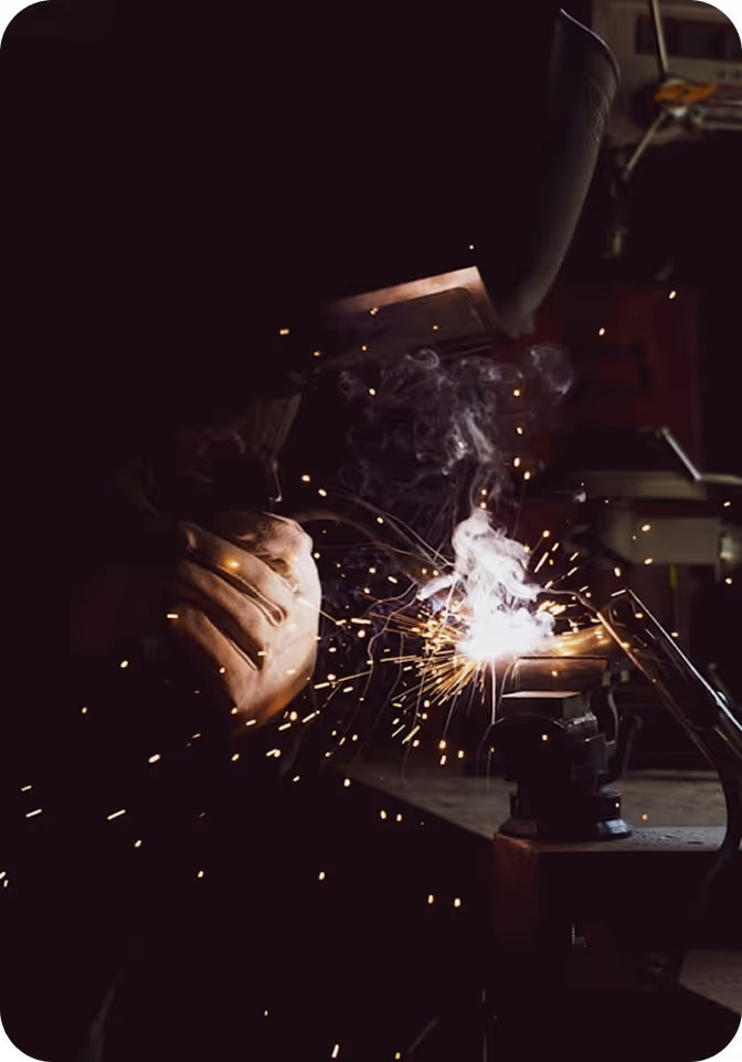 [background image] image of a construction worker welding metal (for a manufacturing plant)