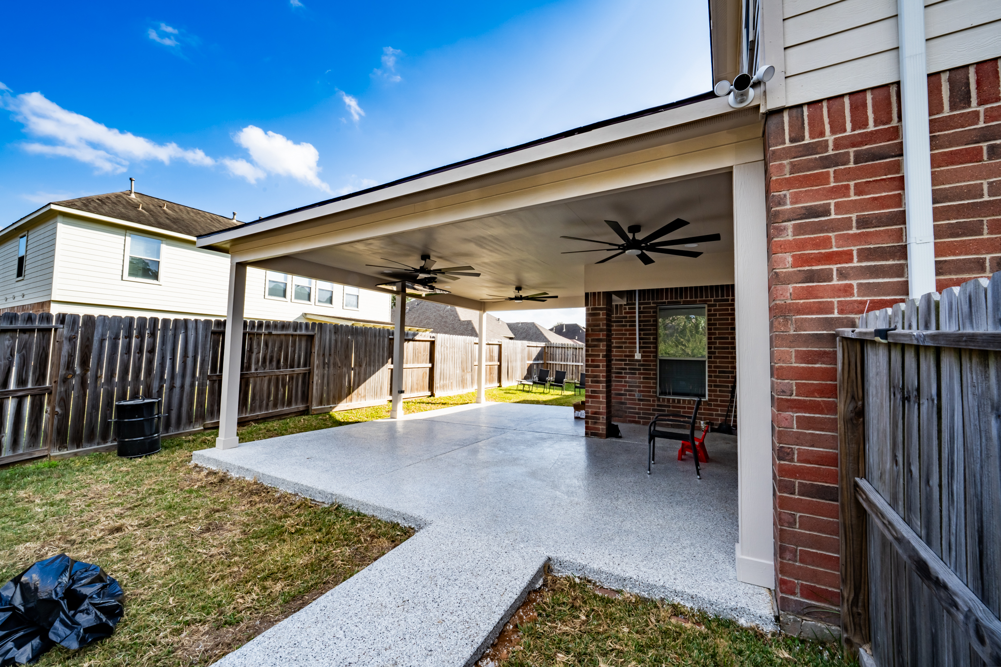 Construction worker pouring concrete into a cinder block foundation with exposed rebar rods.