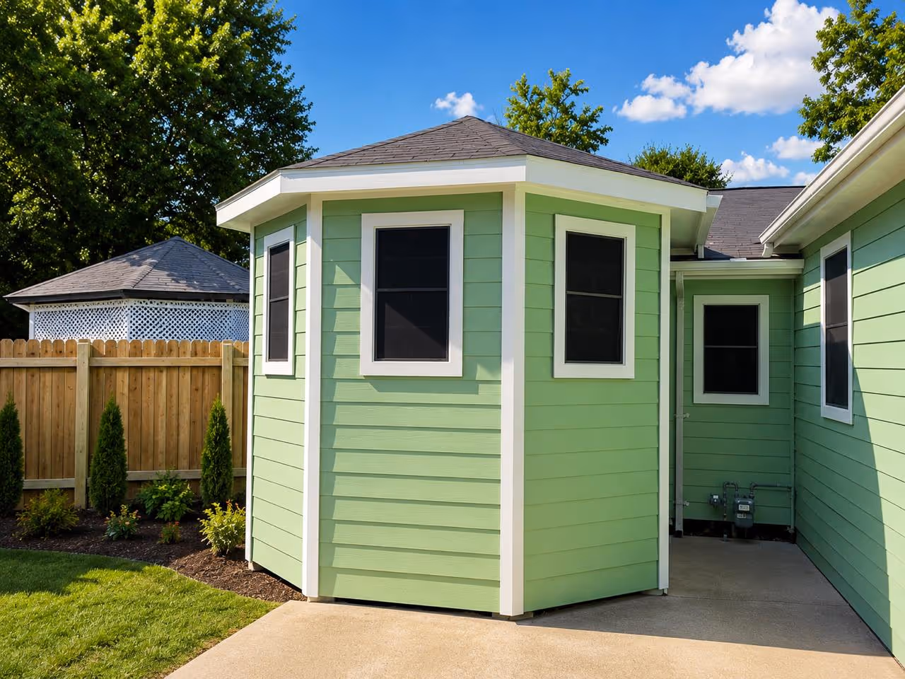 Professional siding installation in Houston showcasing a newly built room addition with light green horizontal lap siding, crisp white trim, and weather-sealed windows.