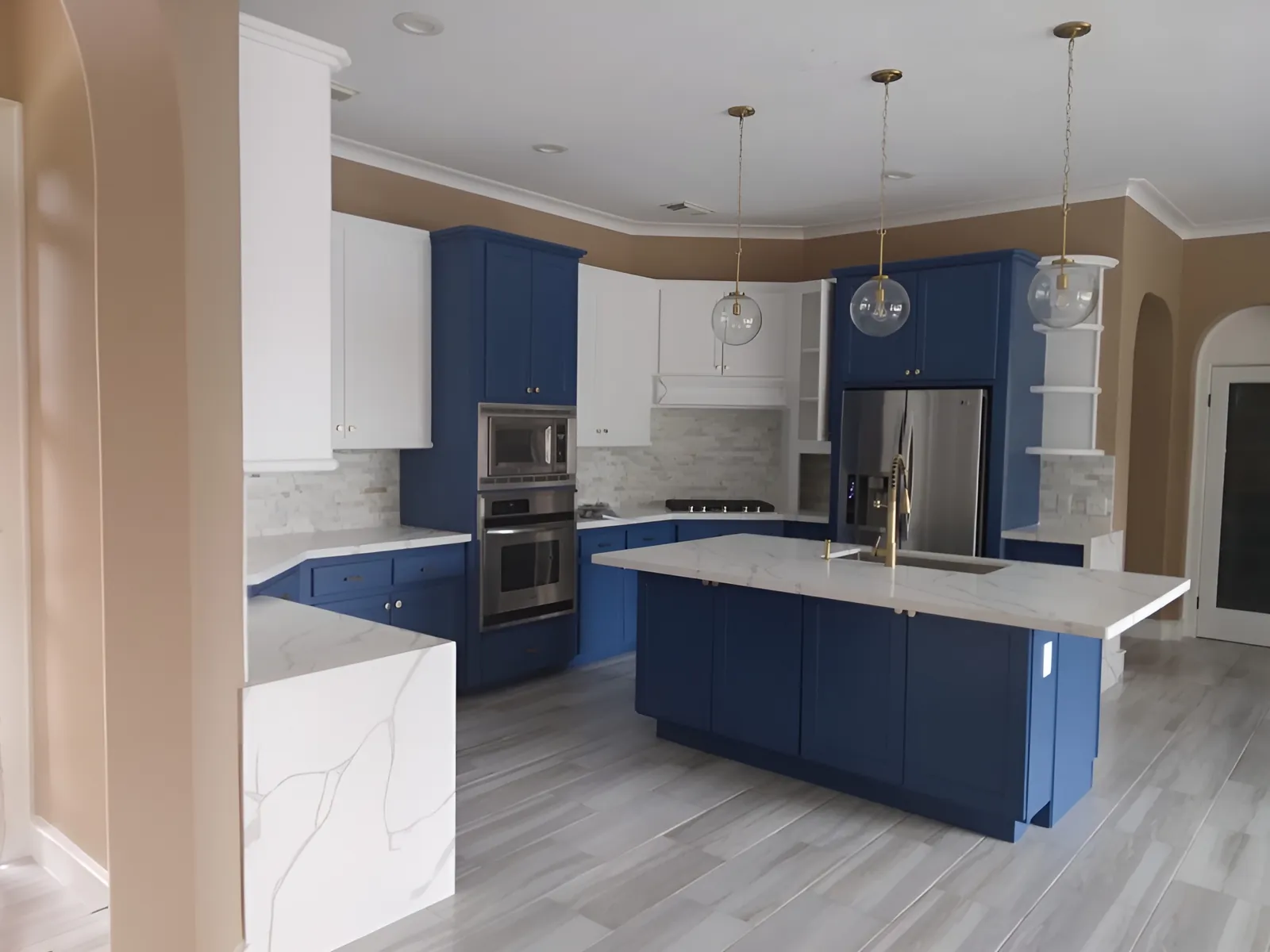 Remodeled Houston kitchen with navy blue cabinets, white quartz countertops, a large island and pendant lights.