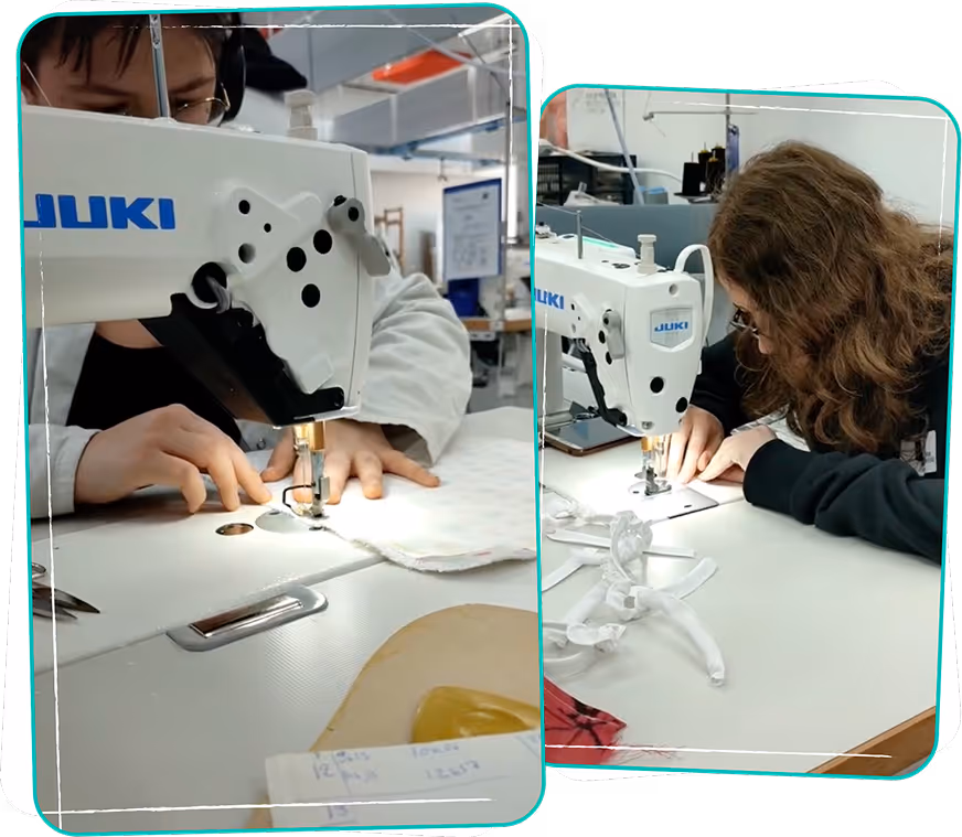 Two people using white JUKI sewing machines to sew fabric on white tables in a workshop environment.