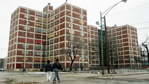 people walking by old apartment building
