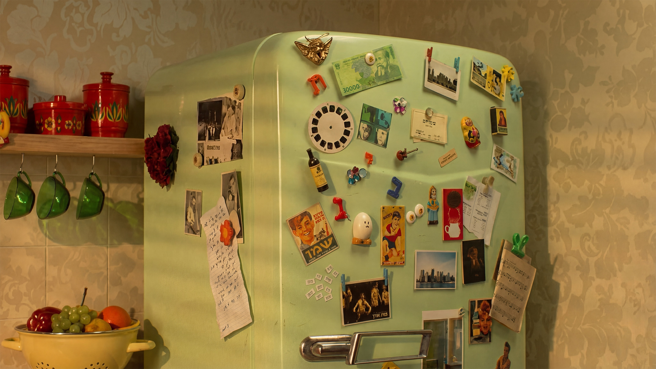 A vintage kitchen refrigerator covered in Israeli cultural memorabilia, photos and magnets, from the documentary series Cultural Heroes