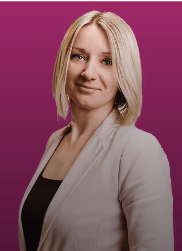 Blonde Frau mit kurzem Haar in beigem Blazer vor lila Hintergrund.