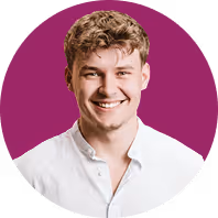 Lächelnder Mann mit lockigem Haar vor lila Kreis, trägt weißes Hemd.