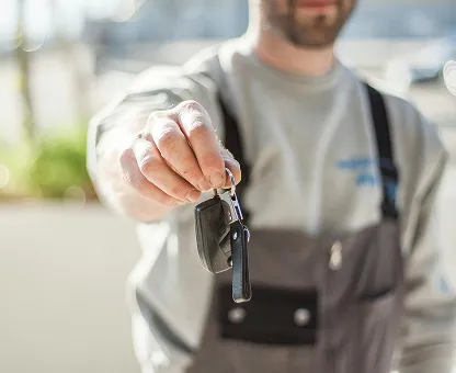 Person holding out a set of car keys towards the camera.
