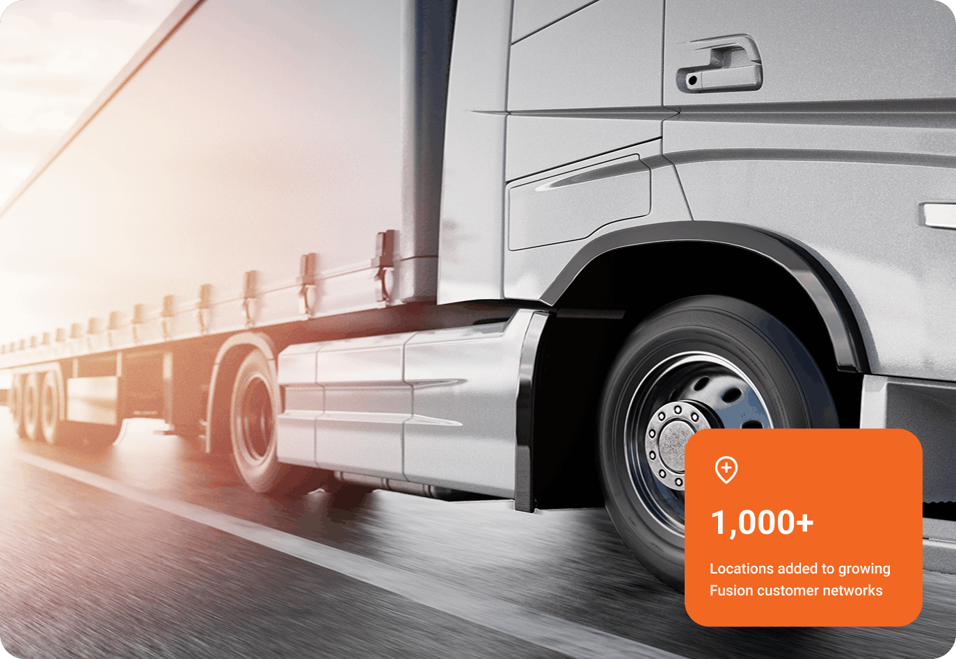 Close-up of a silver semi-truck trailer driving on a highway with sunlight reflecting off its side, with an orange overlay stating 1,000+ locations added to growing Fusion customer networks.