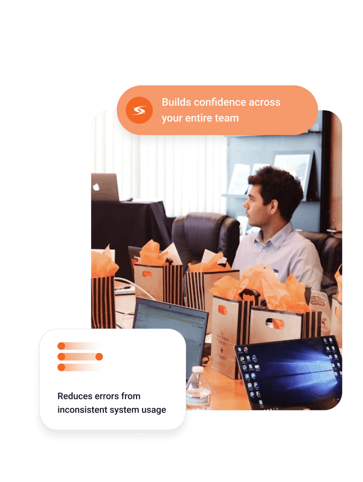 Man seated at conference table with laptops and gift bags, captioned Build confidence across your entire team and Reduces errors from inconsistent system usage.