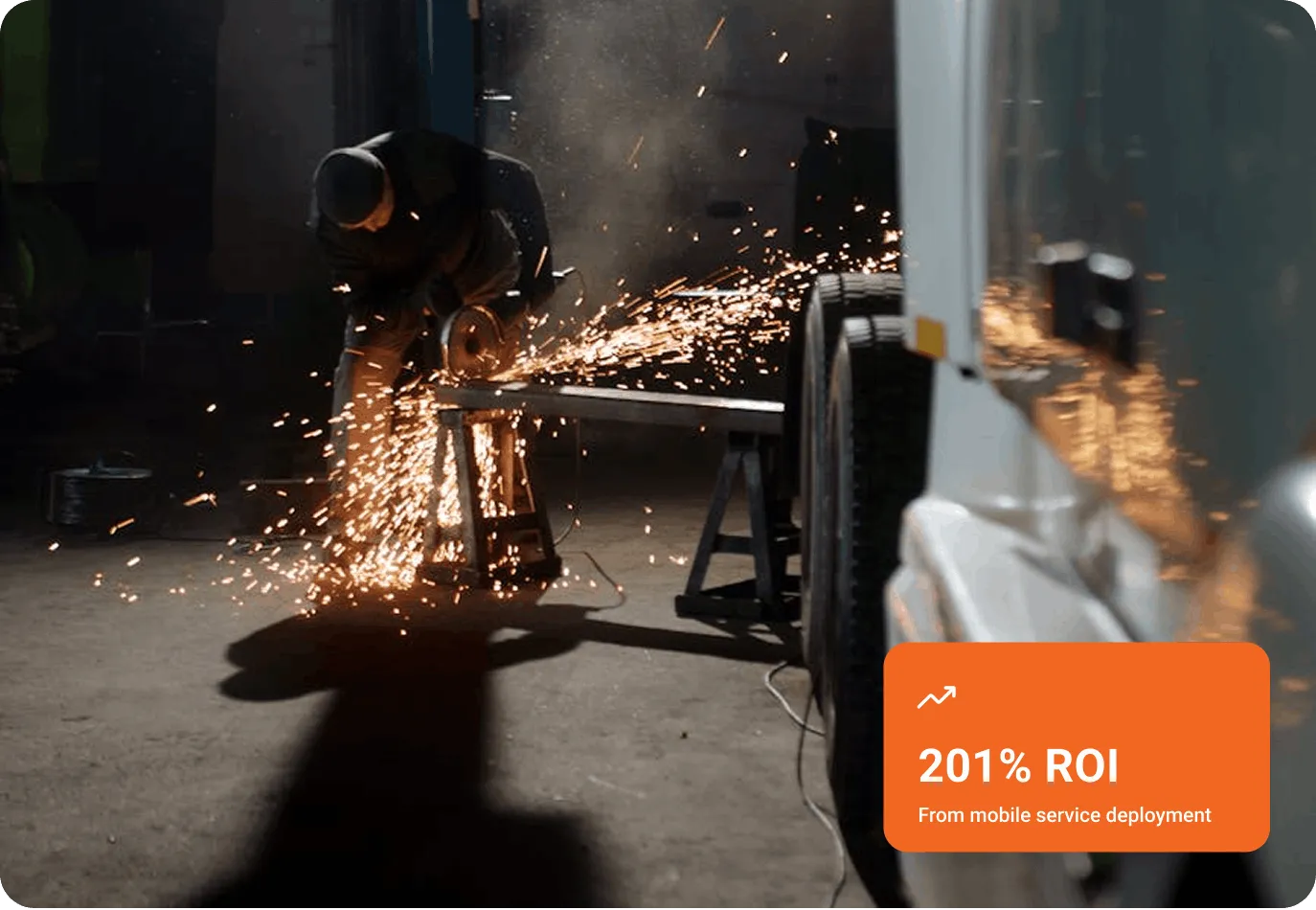 Worker using an angle grinder on metal with sparks flying in an industrial setting.