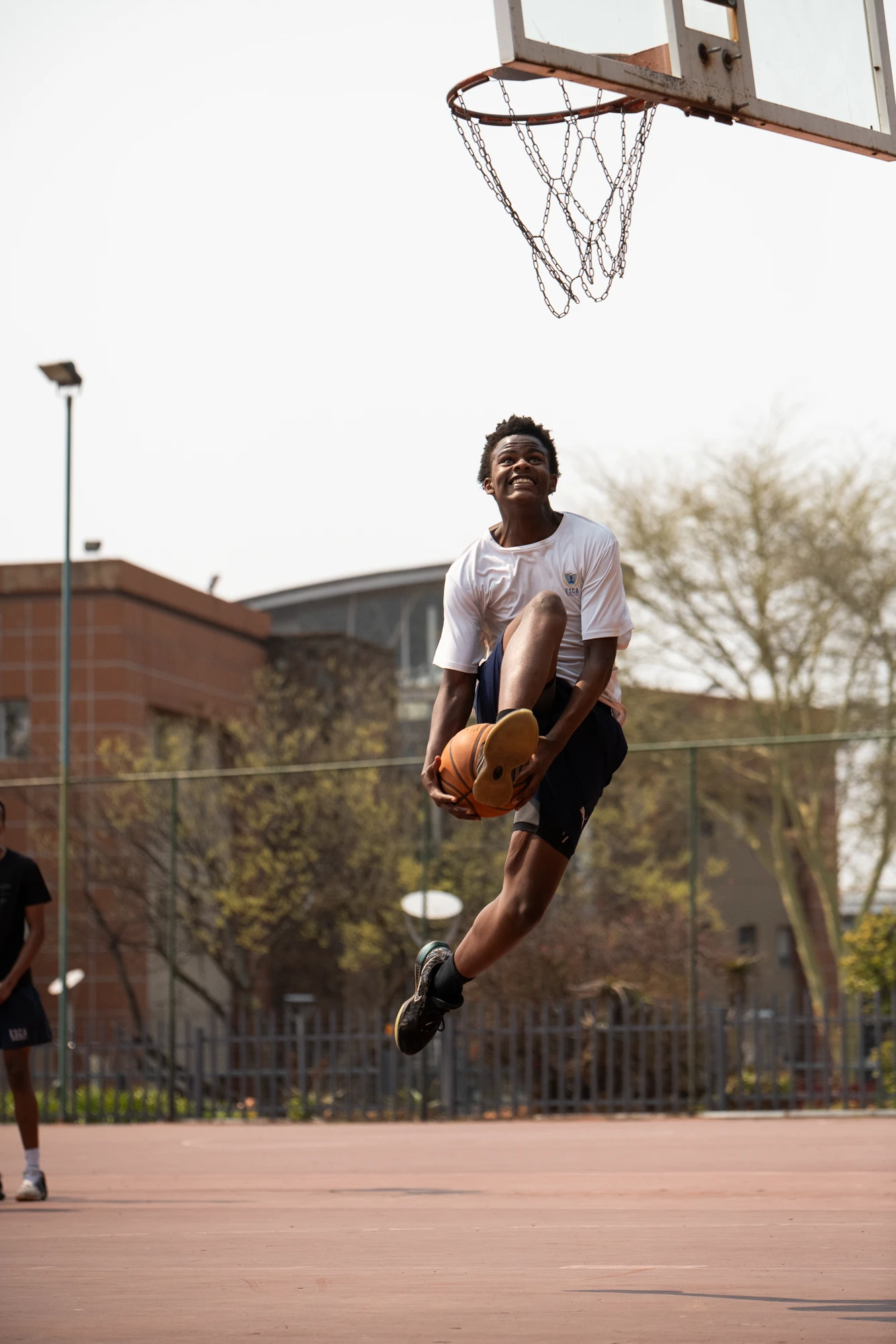 Esca Young Person Dunking Basketball