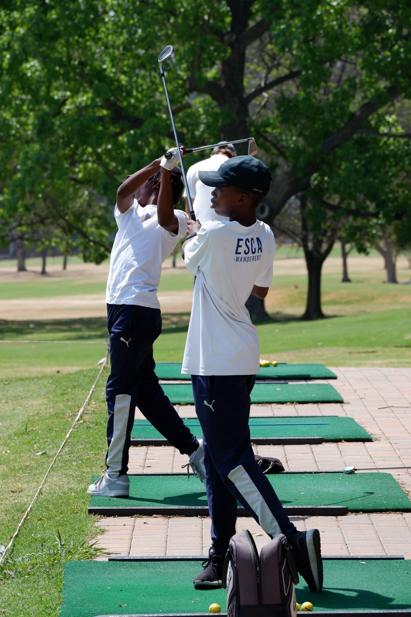 Esca Two Boys Practicing Golf Outdoors