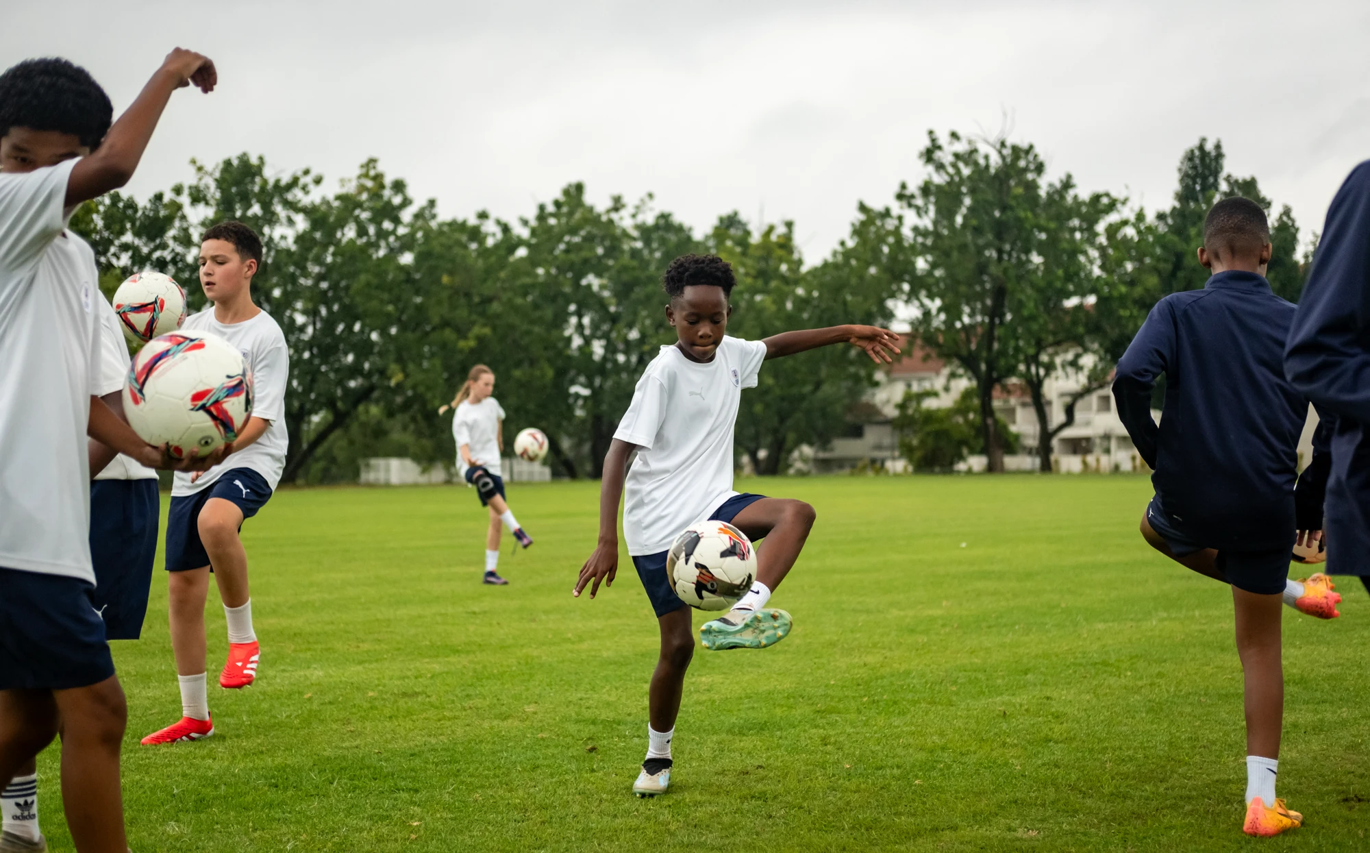 Esca Children Practicing Soccer On Field