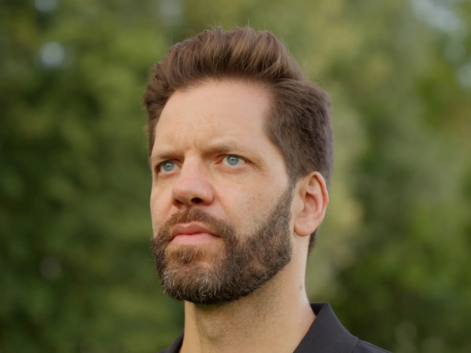 Porträt von Chris Römhild vor grünem Hintergrund