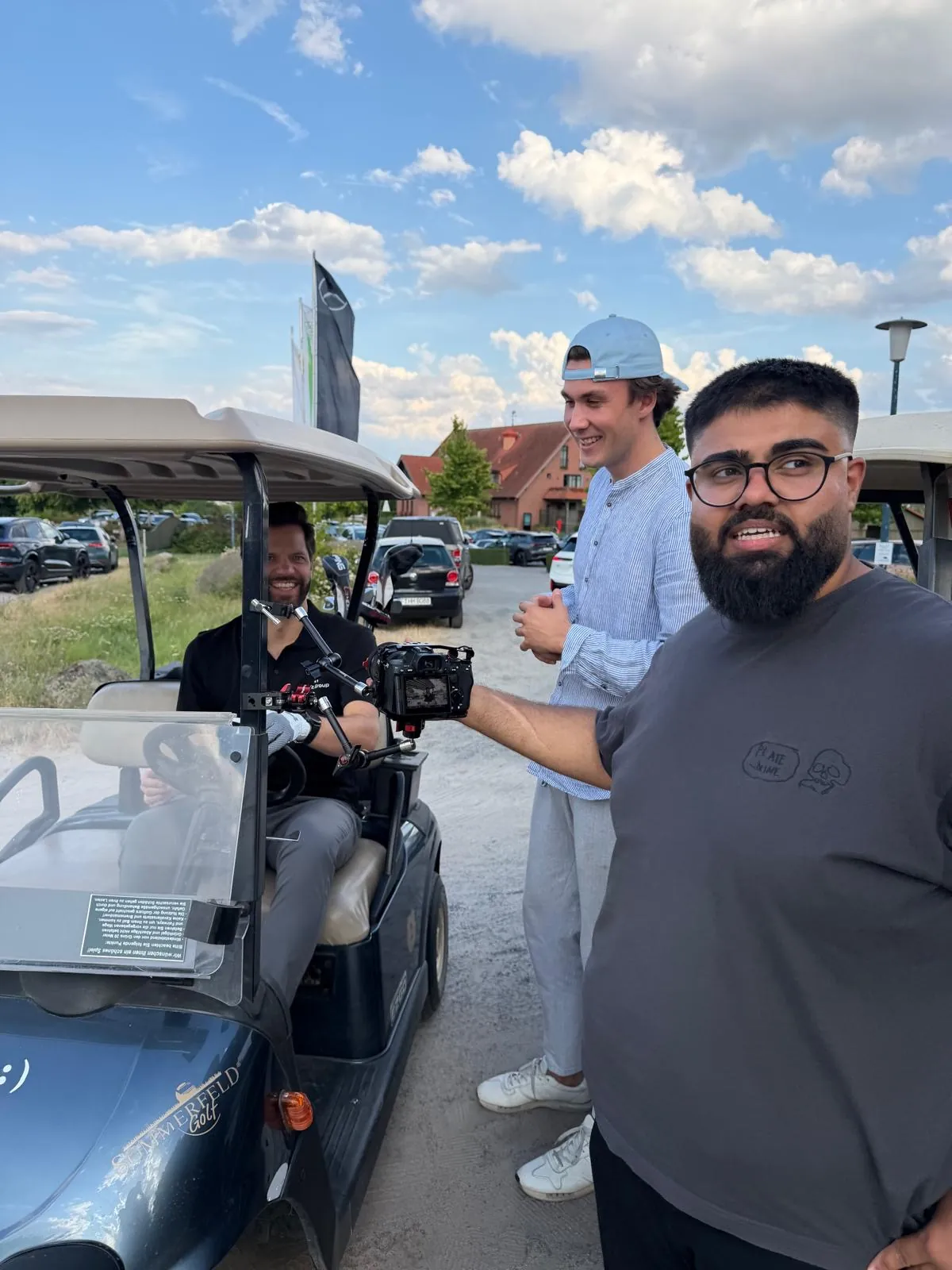 Team mit Kamerarig am Golfcart