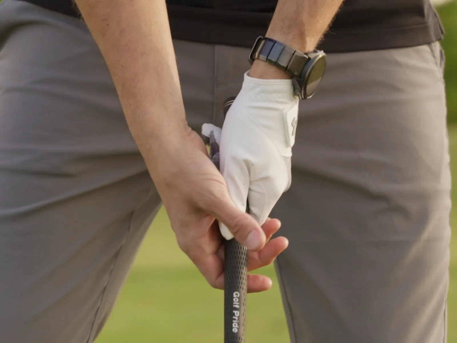Hände mit Golfhandschuh am Griff des Schlägers