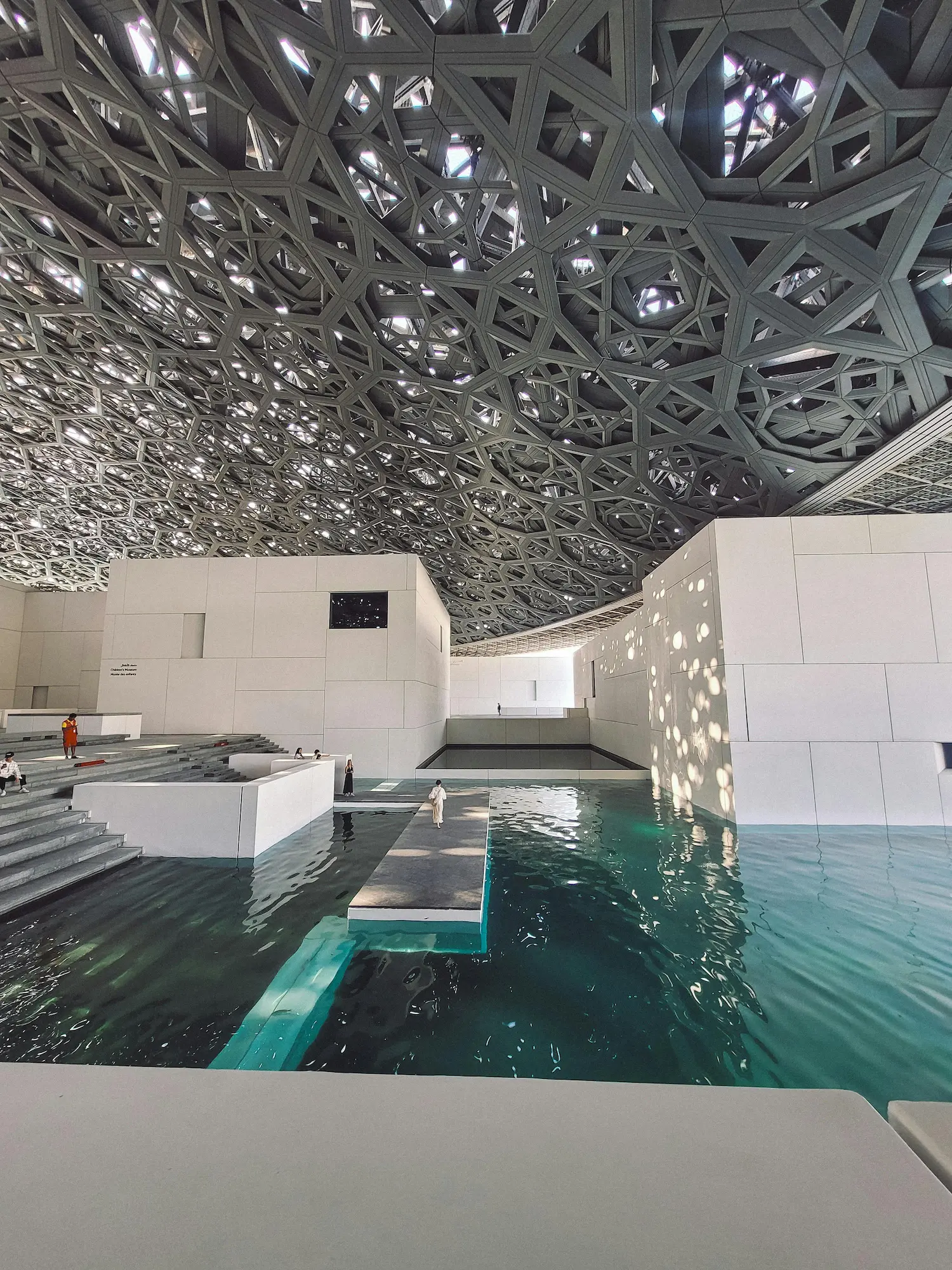 Interior of Louvre Abu Dhabi on Saadiyat Island with geometric dome and light reflections