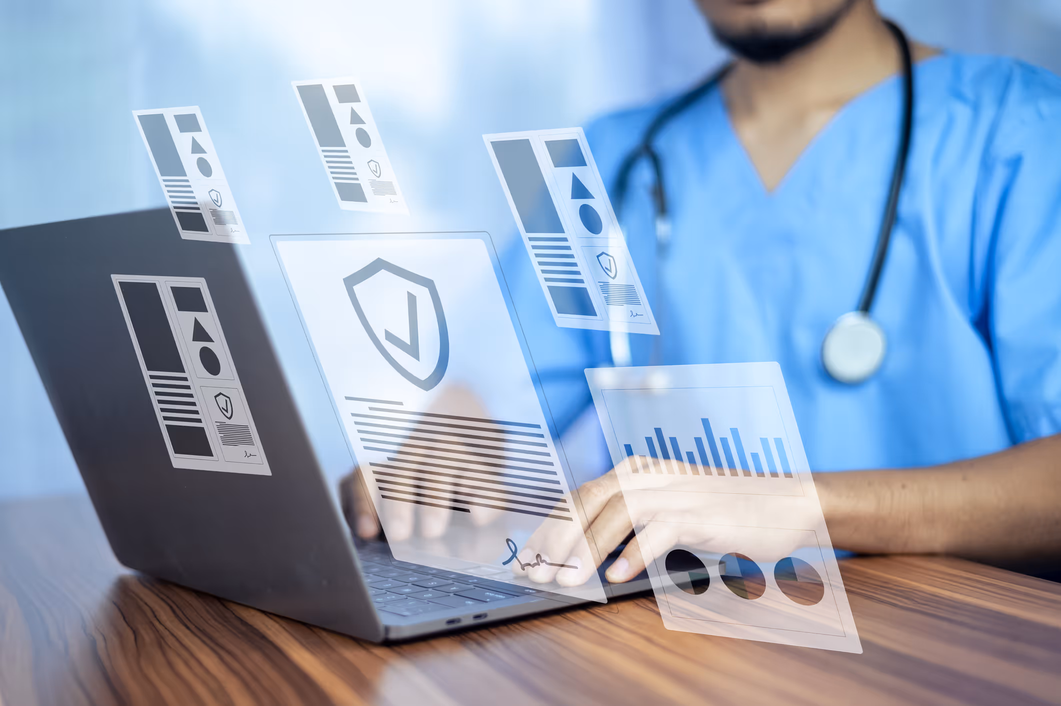 Medical professional in blue scrubs typing on a laptop with holographic medical data and charts floating above the keyboard.