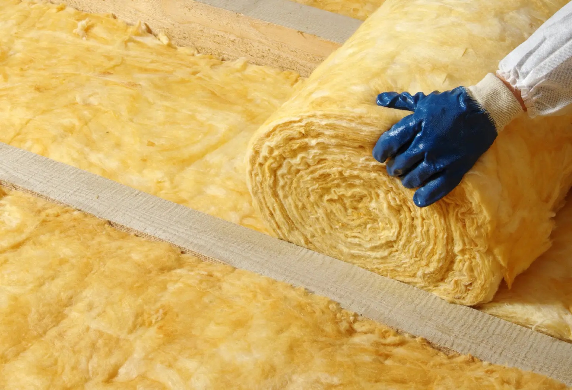 Worker installing a roll of insulation