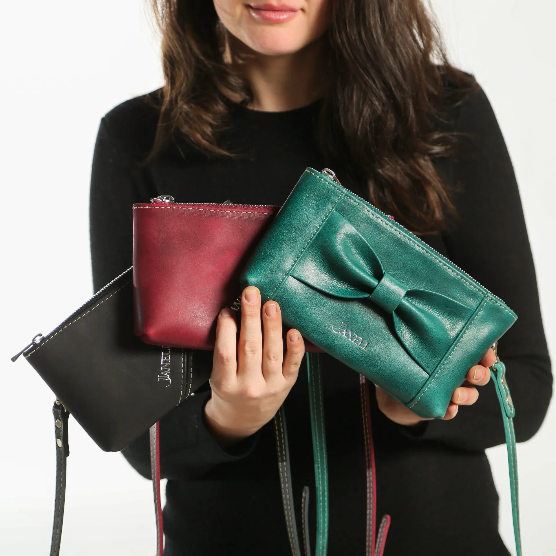 a lady holds hand crafted leather clutches
