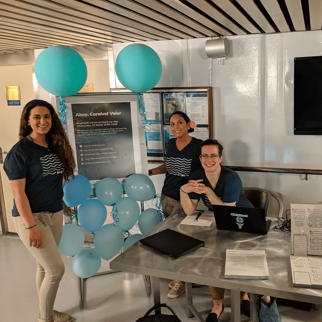 A group of people sitting at a table with laptops.