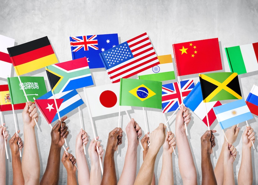 Against a white background, 17 arms hold up a flag in each. The flags are from different countries, including the USA, Australia, Japan, the UK, France, Argentina, Jamaica, China, Italy, and South Africa. They represent the global workforce that Brightwell's payroll solution, Navigator, provides with secure and efficient access to their personal finances.
