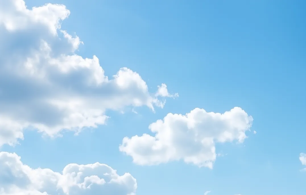 Bright blue sky with scattered fluffy white clouds.