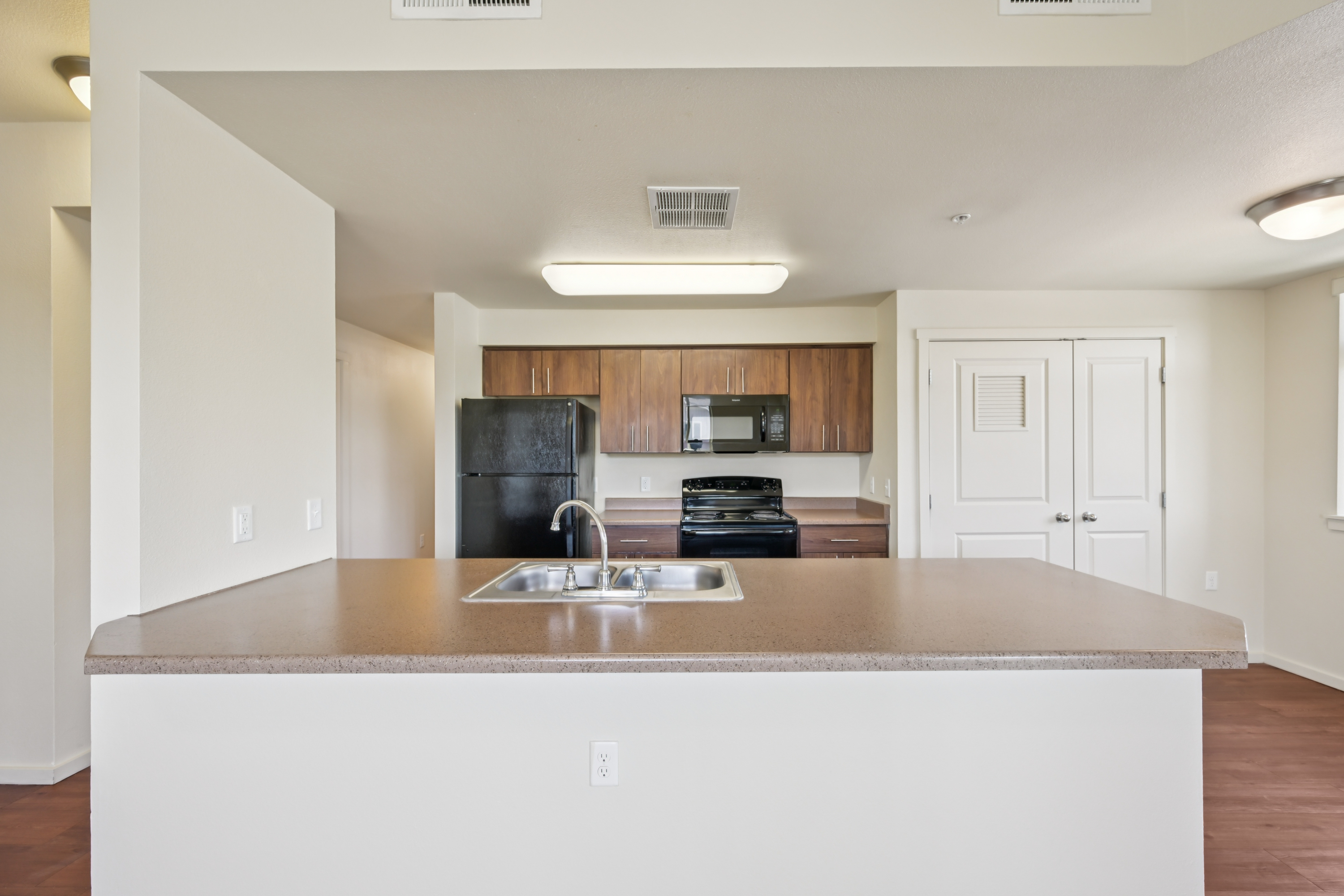 Kitchen with large center island overlooking the open living area at Copper Creek Apartments