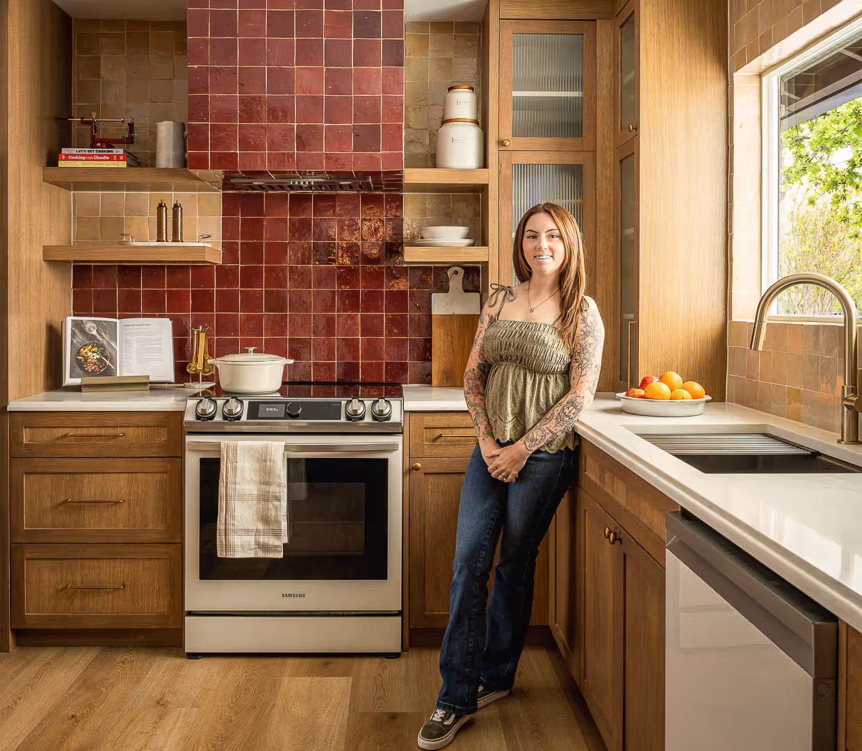 Recently remodeled kitchen with wooden cabinets, red tile backsplash, and stainless steel stove and dishwasher.