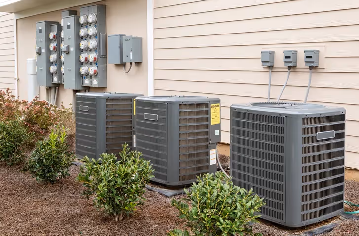 AC condenser units outside a building near electrical boxes.