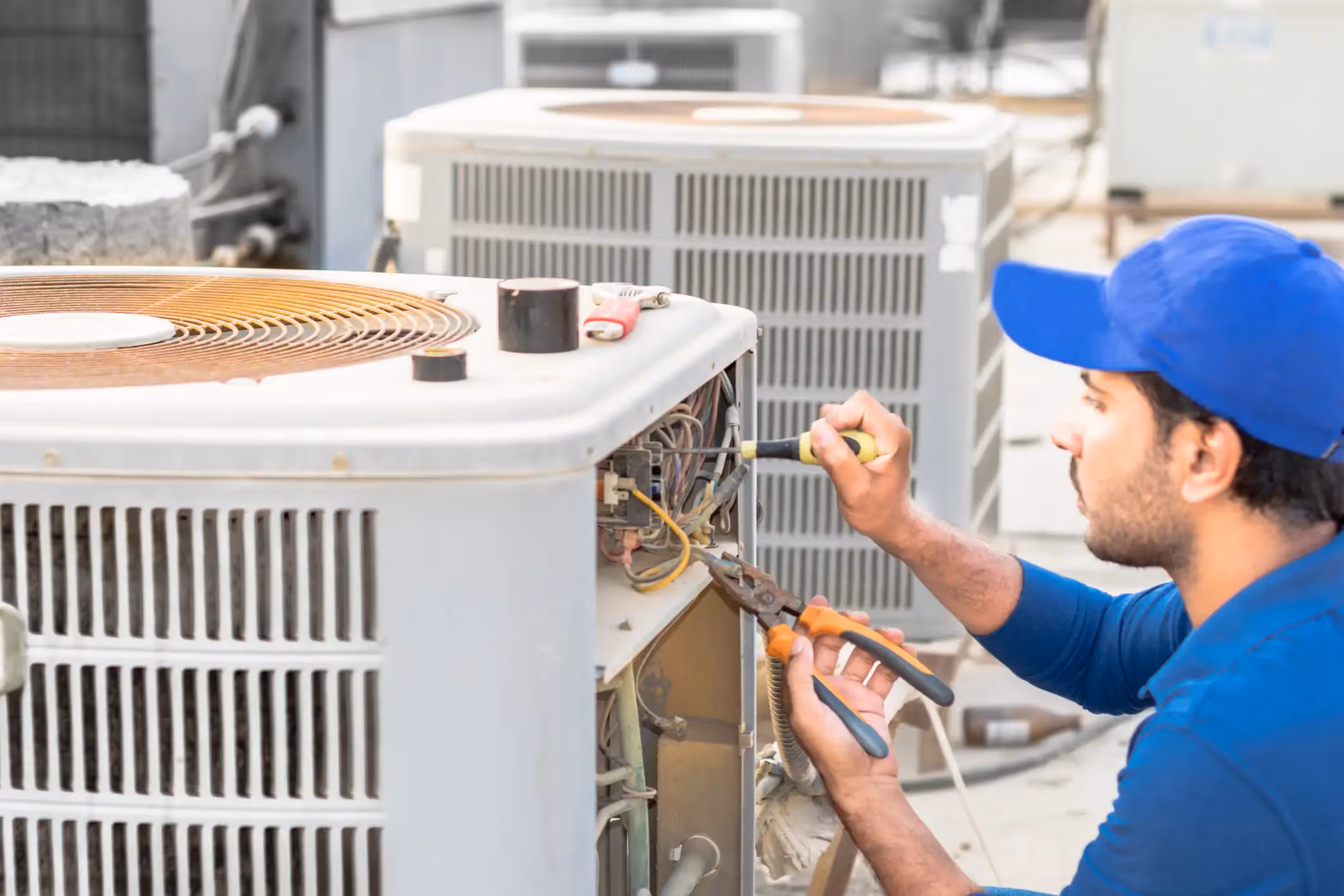 Technician repairing a rooftop air conditioner.