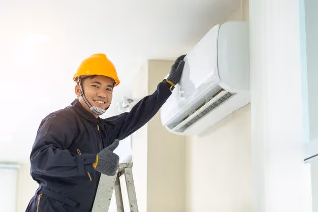 Technician giving thumbs up by air-conditioner.