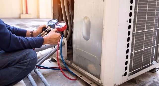 Technician checking pressure with manifold gauges.