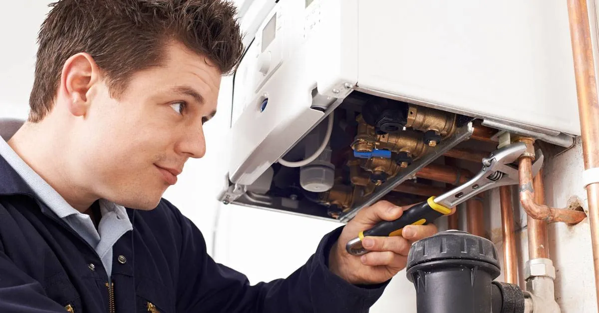 Technician using wrench on heating unit.