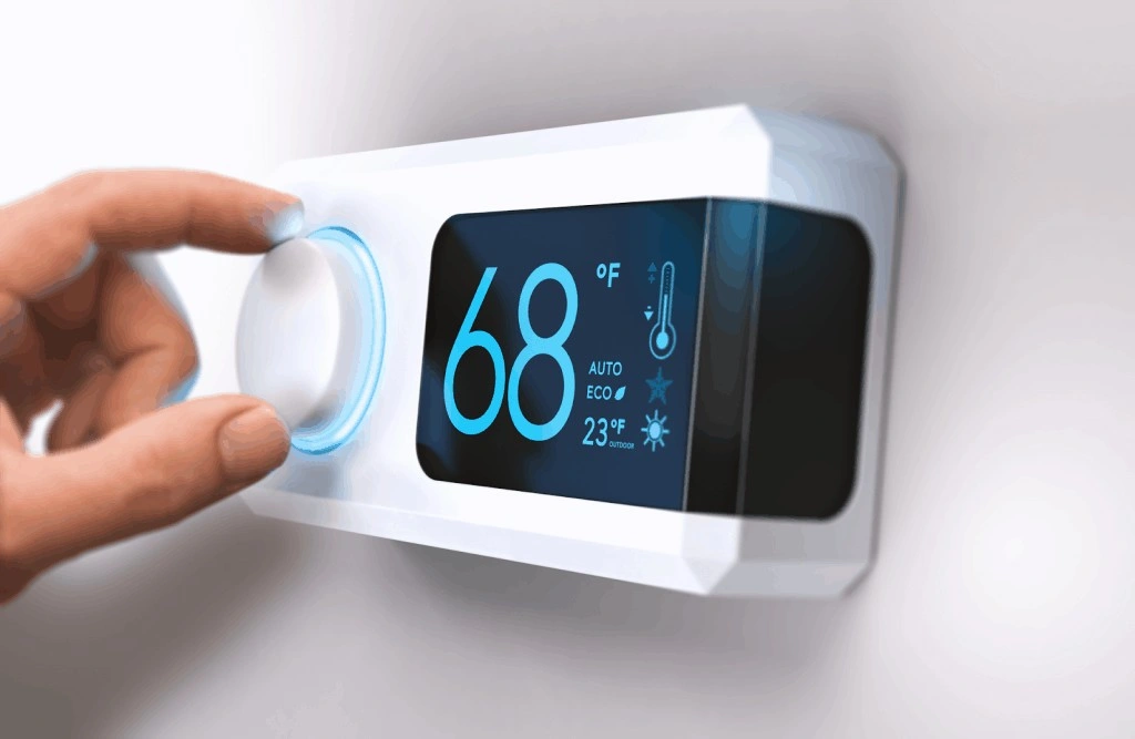 Hand adjusting digital wall smart thermostat.