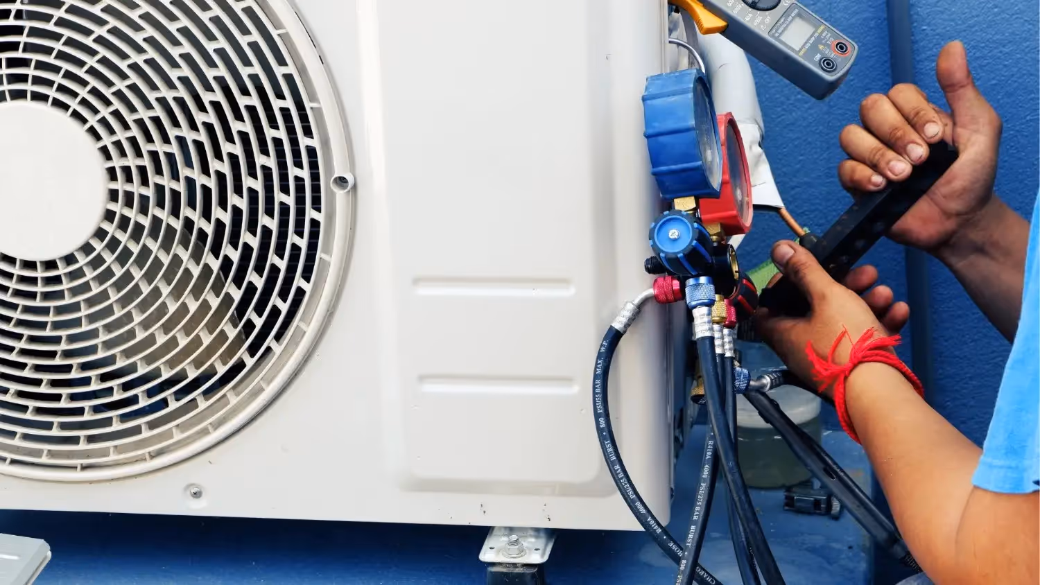 Technician hands adjusting heat pump gauges.