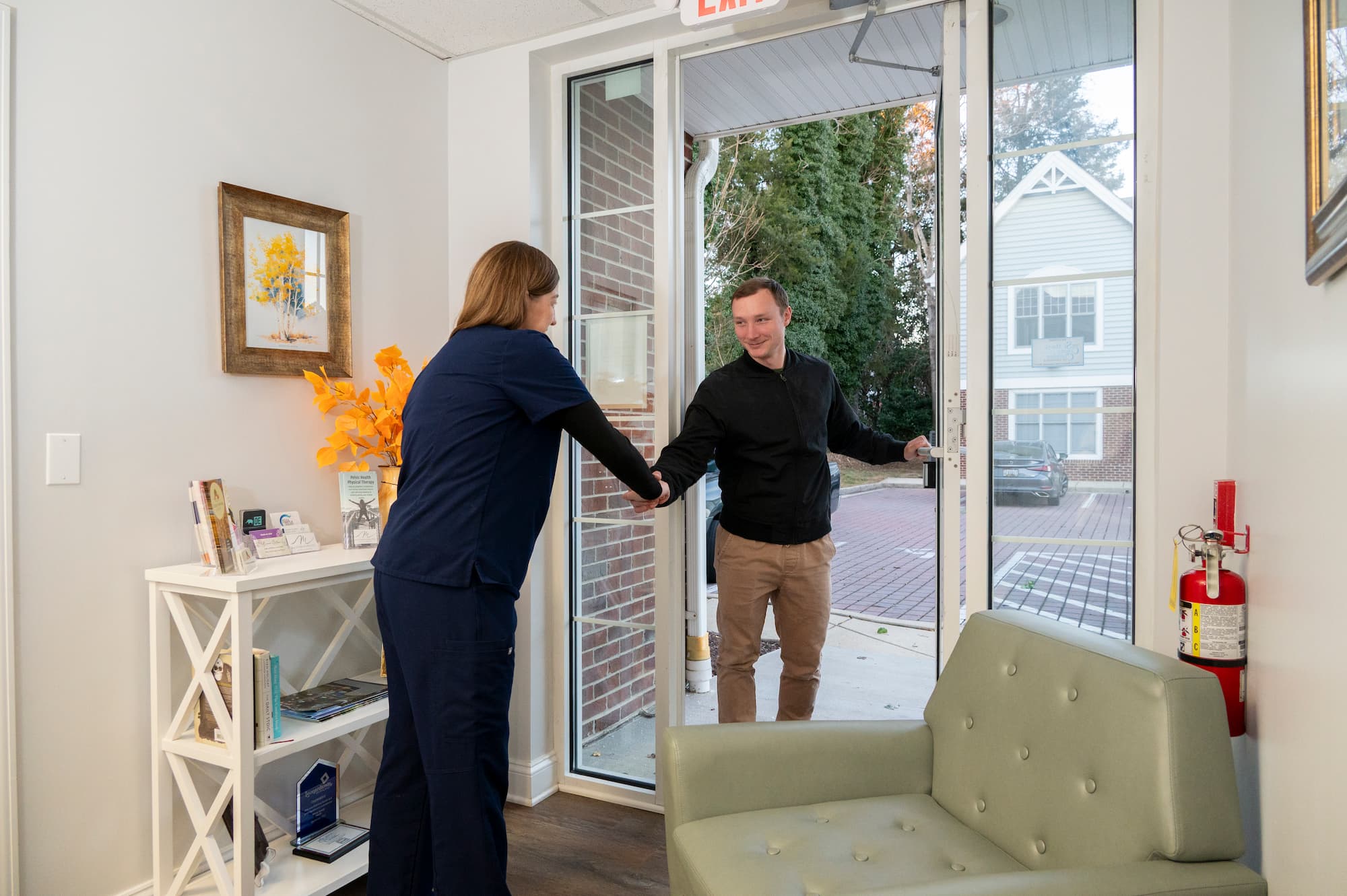 a healthcare provider greeting a patient at the door