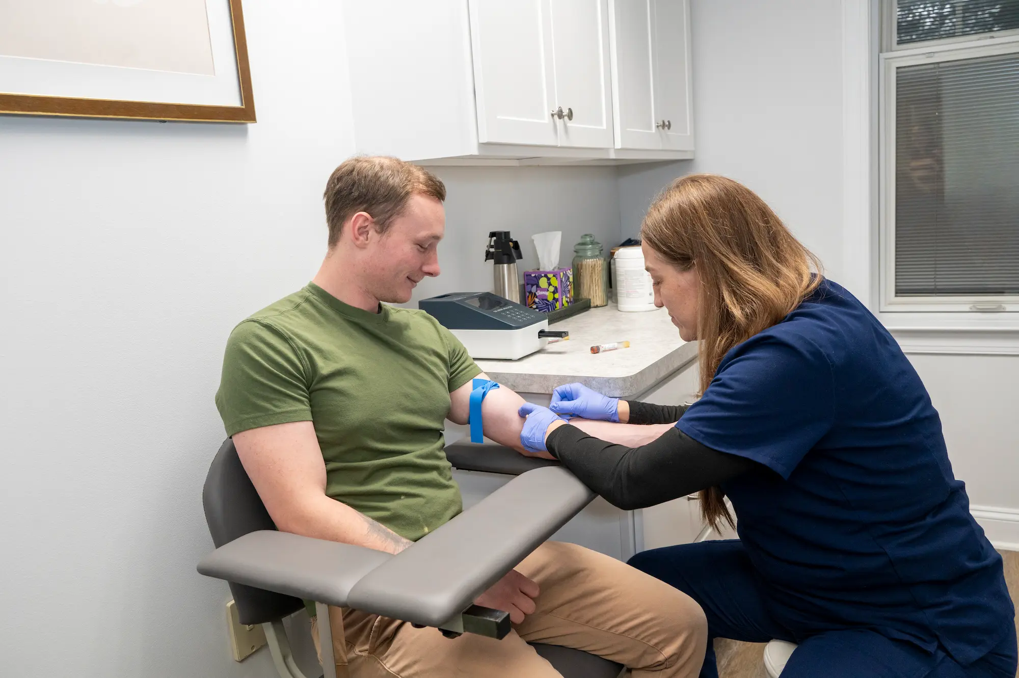 a healthcare provider checking a patient's arm for veins